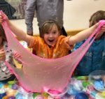 child stretching slime, looking amazed